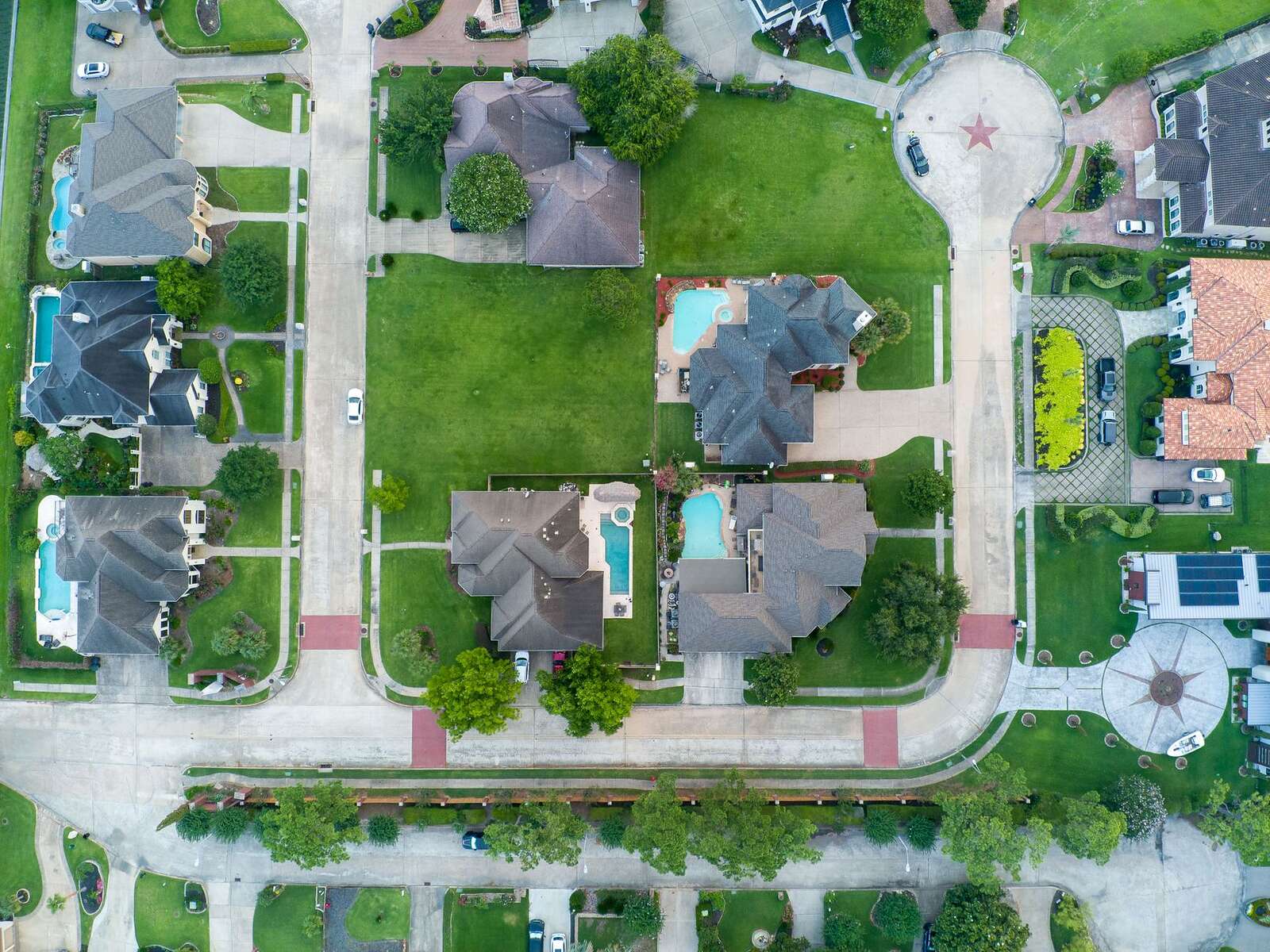 Aerial view of a Texas subdivision of shingle roofs, pools and cul-de-sacs