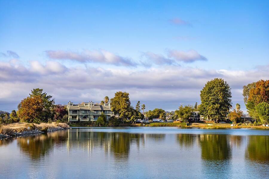 A house among green trees beside a lake