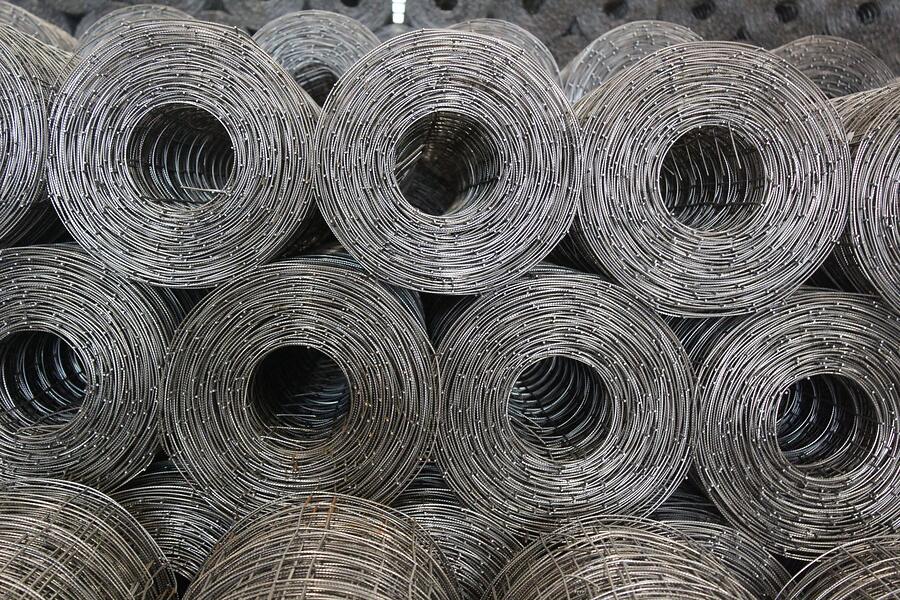 Rolls of galvanized steel wire mesh stacked on a shelf