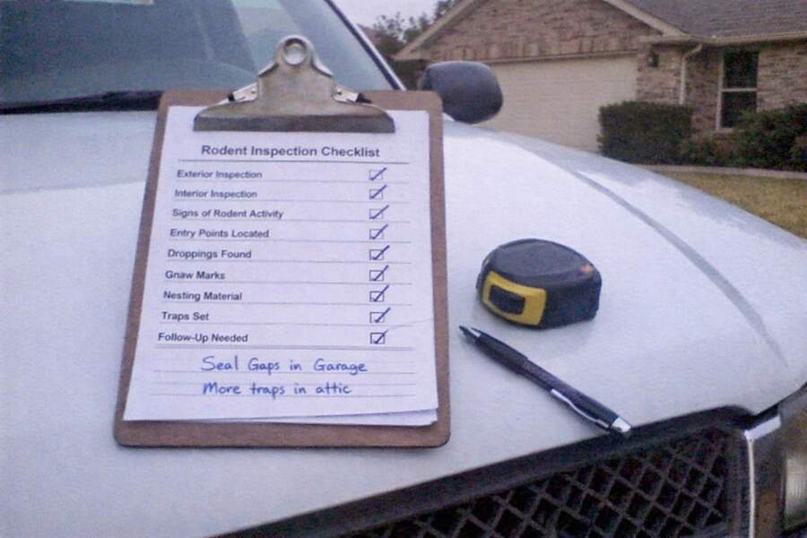 An inspection checklist on a clipboard resting on a truck hood