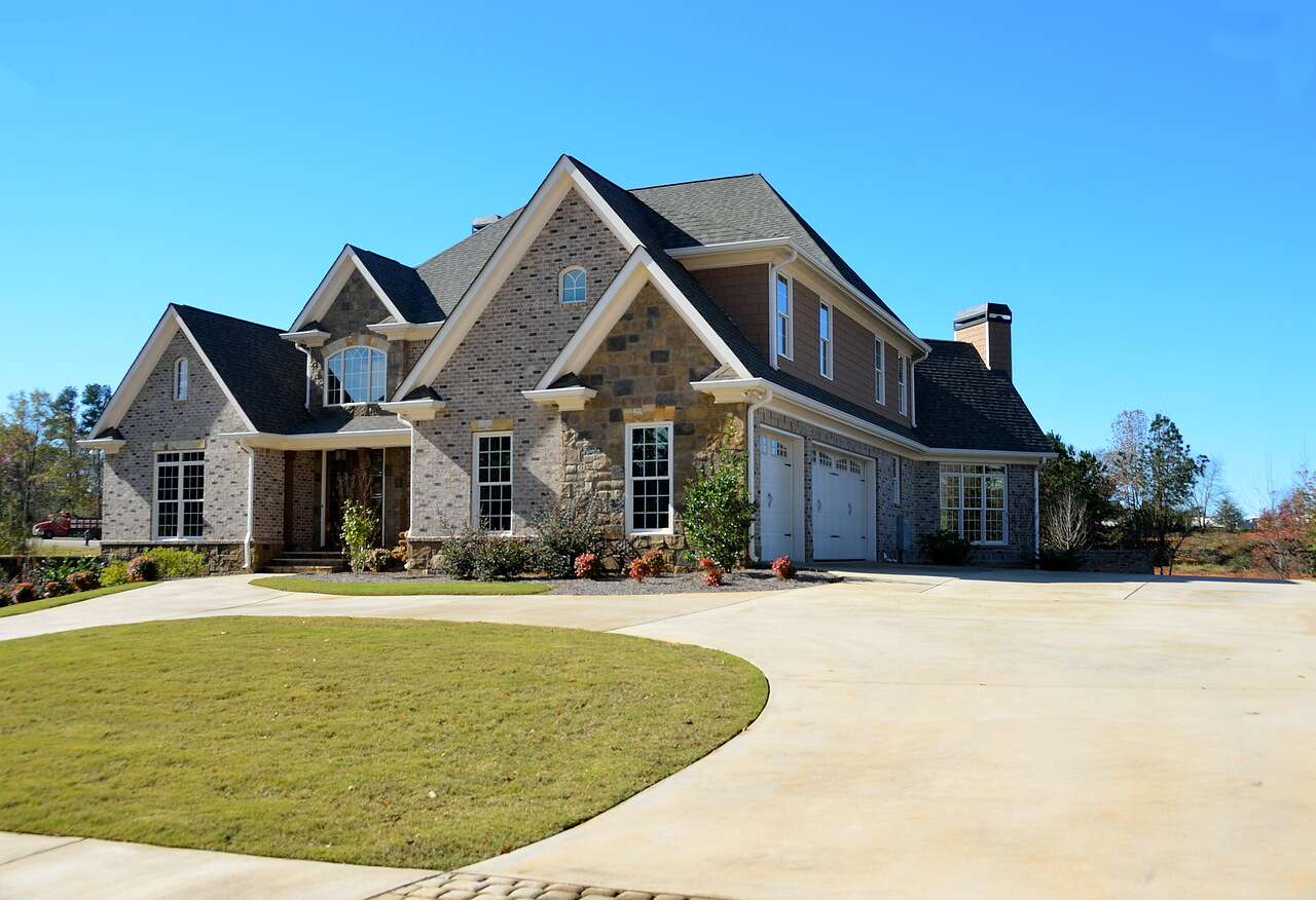 A large brick house with a three-car garage and a wide driveway