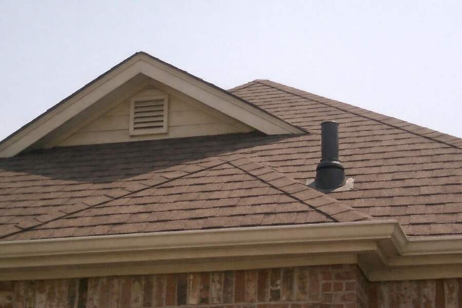 Gables and hips of a composition shingle roof with a gable vent under the peak