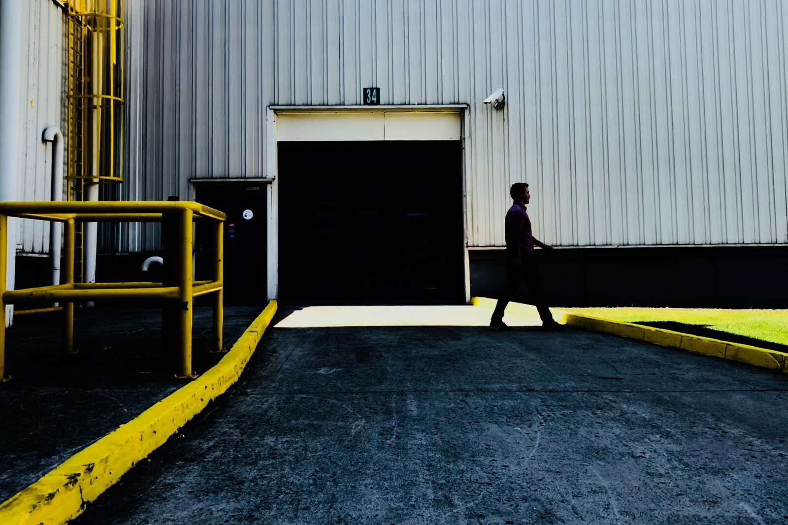 A person walking past a large roll-up door on an industrial building